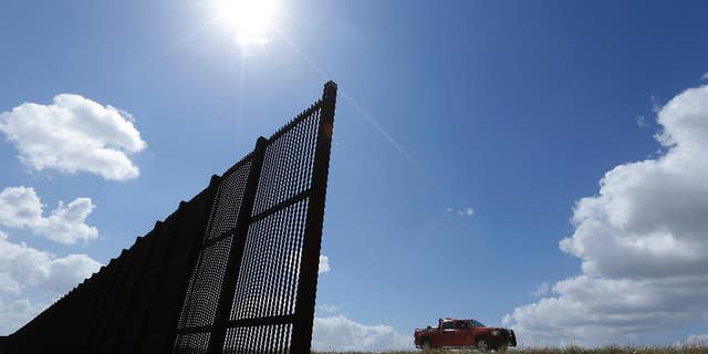FILE - In this Sept. 6, 2012, file photo, cotton farmer Teofilo "Junior" Flores drives his truck along the U.S.-Mexico border fence that passes through his property in Brownsville, Texas. President Donald Trump’s vow to accelerate construction of a “contiguous, physical wall” along the Mexican border is slamming into a Washington reality _ who’s going to pay for it and how? (AP Photo/Eric Gay, File)