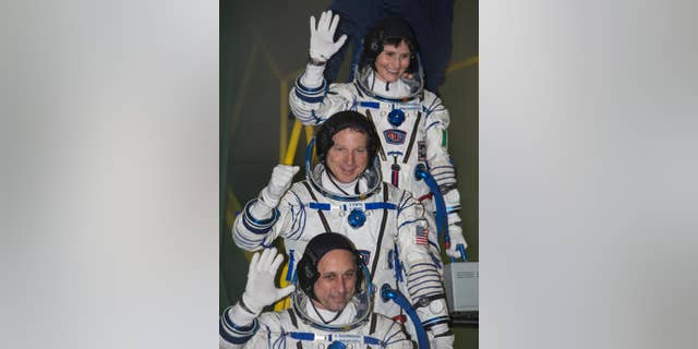 File photo - U.S. astronaut Terry Virts, centre, Russian cosmonaut Anton Shkaplerov, bottom, and Italian astronaut Samantha Cristoforetti, crew members of the mission to the International Space Station, ISS, gesture prior the launch of Soyuz-FG rocket at the Russian leased Baikonur cosmodrome, Kazakhstan, Monday, Nov. 24, 2014.