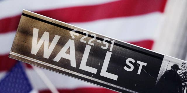 FILE - This Aug. 9, 2011 file photo shows a Wall Street street sign near the New York Stock Exchange, in New York. U.S. stocks rose Thursday, Sept. 4, 2014, after the European Central Bank surprised traders by trimming its main interest rate to a record low, and announcing that it would purchase asset-backed securities in an effort to stimulate the region's ailing economy. (AP Photo/Mark Lennihan, File)