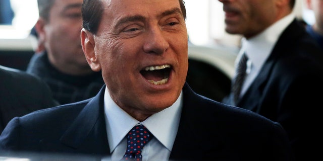 Former Italian premier Silvio Berlusconi smiles as he arrives at Milan's central train station, Italy, Saturday, Dec. 29, 2012. Italian Premier Mario Monti announced Friday he is heading a new campaign coalition made of up centrists, business leaders and pro-Vatican forces who back his "ethical" vision of politics, aiming for a second mandate in office if his fledging reform movement wins big in parliamentary elections. Monti was appointed premier 13 months ago after his scandal-plagued predecessor Silvio Berlusconi failed to stop Italy from sliding deeper into the eurozone debt crisis. He quit earlier this month after Berlusconi pulled his party's support from Monti's government, but is now continuing in a caretaker role until the next elections. (AP Photo/Luca Bruno)
