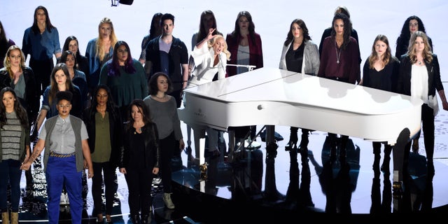 Lady Gaga, center, performs "Til It Happens To You" that is nominated for best original song from "The Hunting Ground" on stage with survivors of abuse at the Oscars on Sunday, Feb. 28, 2016, at the Dolby Theatre in Los Angeles. (Photo by Chris Pizzello/Invision/AP)
