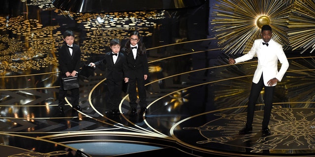 Host Chris Rock, right, and children participate in a skit at the Oscars on Sunday, Feb. 28, 2016, at the Dolby Theatre in Los Angeles.
