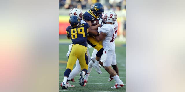 California's Daniel Lasco, second from right, is picked up by Stanford's A.J. Tarpley, right, during the second half of an NCAA college football game Saturday, Nov. 22, 2014, in Berkeley, Calif. At left is California's Stephen Anderson (89). (AP Photo/Ben Margot)