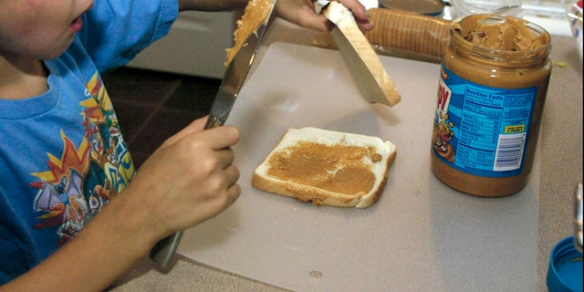 ** ADVANCE FOR TUESDAY, JULY 12 ** Nick, 7, makes a peanut butter sandwich to go in his lunch Monday, June 22, 2005 in St. Louis. Nick's mom Sherry Claxton, a licensed dietician, lets her three kids make their own lunches butkeeps a close eye on what goes in them.(AP photo/Tom Gannam)