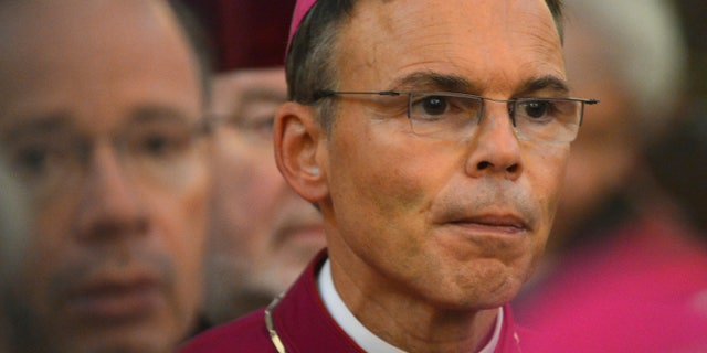 FILE - In this Sept. 24, 2013 file picture Limburg Bishop Franz-Peter Tebartz-van Elst, right, attends a mass during the meeting of German bishops in Fulda, Germany, A German court says it’s shelved a case against a German bishop removed from his diocese by the Vatican over a furor caused by the cost of his new residence. The Hamburg administrative court said Monday Nov. 18, 2013 the case against Limburg Bishop Franz-Peter Tebartz-van Elst would be closed upon his payment of a 20,000 euro ($27,000) fine. The bishop was accused of giving false statements in a case he brought against Der Spiegel magazine over its report he flew first-class to India on a trip to visit poor children. (AP Photo/dpa,Arne Dedert)