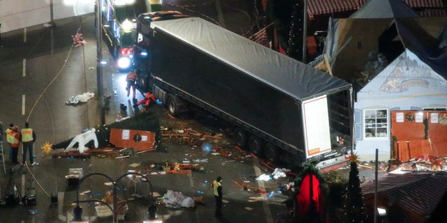 A used suit of a forensic investigator lies on a Christmas tree where a truck ploughed through a crowded Christmas market killing 12 people in the west of Berlin, Germany, December 20, 2016 REUTERS/Fabrizio Bensch - RTX2VT41