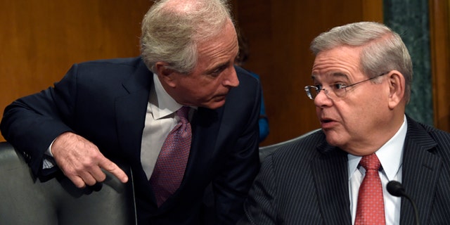FILE - In this Jan. 27, 2015 file photo, Sen. Robert Menendez, D-N.J., right, and Sen. Bob Corker, R-Tenn. talk on Capitol Hill in Washington. A bipartisan bill in the Senate would set up a nonprofit foundation to help eliminate forced labor and sexual servitude around the world. The Senate Foreign Relations Committee is to vote Thursday on the bill introduced by chairman Sen. Bob Corker, R-Tenn., and Robert Menendez, D-N.J., the ranking Democrat on the committee. (AP Photo/Susan Walsh, File)