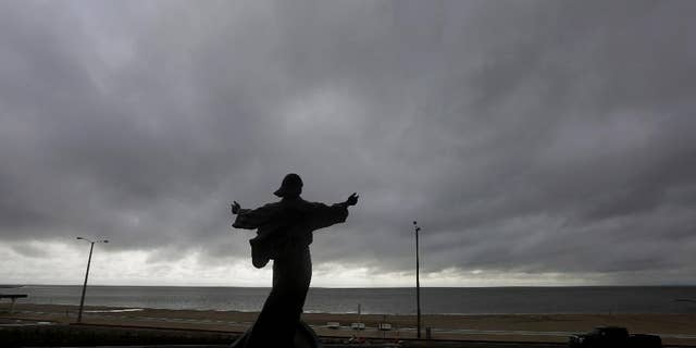 A statue of Jesus calming the sea titled "It is I" faces the bay and gulf, in Corpus Christi, Tuesday, June 16, 2015, as Tropical Storm Bill begins to make landfall.