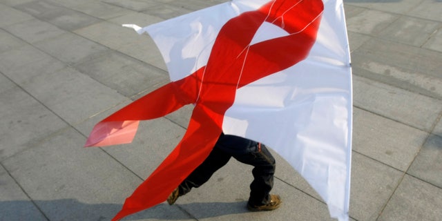 A child flies a kite with a red ribbon during a World AIDS Day event in Beijing November 30, 2008. REUTERS/Jason Lee