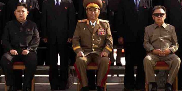 Released Sept. 30: Kim Jong Un, left, the youngest son of North Korean leader Kim Jong Il, right, poses with newly elected members of the Workers' Party of Korea. (Best quality available)