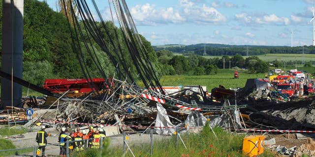 Firefighters stand near a collapsed scaffolding  at a highway bridge near Werneck northern Bavaria, Germany Wednesday June 15, 2016. German news agency dpa  is reporting that the scaffolding has collapsed on a highway bridge that was under construction in southern Germany.  ( Nicolas Armer/dpa via AP)