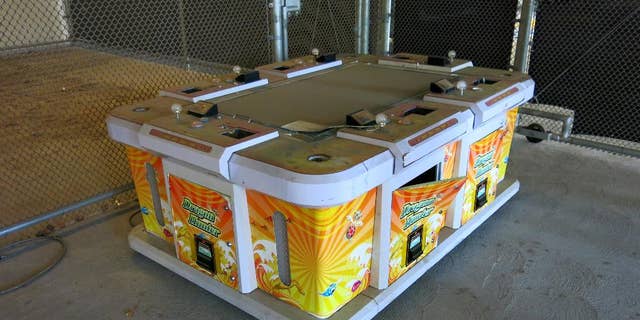 This Friday, June 17, 2016, photo shows a six-seater arcade game seized by the Westminster Police during a raid of an illegal gambling house known as "slaphouses," called so because of the sound players' hands make when hitting the machine controls in Westminster, Calif. Gambling has long been popular in the Vietnamese community that settled in Orange County after the fall of Saigon in 1975 and has since grown to 200,000. (AP Photo/Amy Taxin)