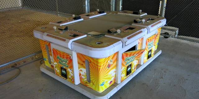 This Friday, June 17, 2016, photo shows a six-seater arcade game seized by the Westminster Police during a raid of an illegal gambling house known as "slaphouses," called so because of the sound players' hands make when hitting the machine controls in Westminster, Calif. Gambling has long been popular in the Vietnamese community that settled in Orange County after the fall of Saigon in 1975 and has since grown to 200,000. (AP Photo/Amy Taxin)