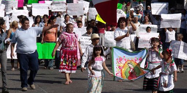 People demonstrate in favor of the drug trafficking organization 'La Familia' and its late leader Nazario Moreno Gonzalez in Apatzingan, Mexico, Sunday Dec. 12, 2010. Moreno was killed on Thursday in Apatzingan during two days of shootouts between gunmen and federal police, according to the government.