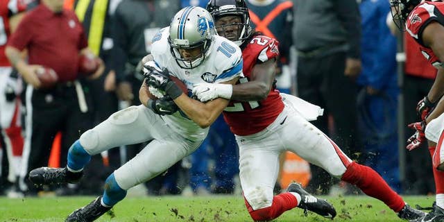 Atlanta Falcons cornerback Desmond Trufant (21) tackles Detroit Lions wide receiver Corey Fuller (10) in the second half of the NFL football game at Wembley Stadium, London, Sunday, Oct. 26, 2014. (AP Photo/Matt Dunham)