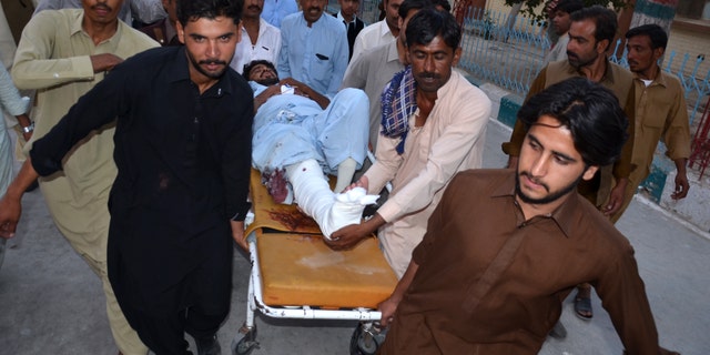 People rush an injured person to a hospital after a bomb blast in Pakistan.