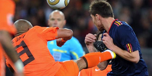 FILE - In this Sunday, July 11, 2010 file photo, Netherlands' Nigel de Jong, left, fouls Spain's Xabi Alonso during the World Cup final soccer match between the Netherlands and Spain at Soccer City in Johannesburg, South Africa. The days of fluent, attacking "total football" are long gone for the Netherlands. Now, results matter more than the way they are achieved. Anybody expecting the Netherlands to revert to the type of free-flowing attacking play that was long the hallmark of Orange teams when Louis van Gaal’s team takes on Spain on Friday should think again. Van Gaal has signaled he will likely play five defenders against Spain to stifle the defending world champion’s own fluent attacking style. That could revive memories of the brutal 2010 final in which eight Dutch players were booked and one sent off. Robin van Persie said Sunday he has no regrets about the 2010 campaign.“I think we can look back with pride” at 2010, he says. (AP Photo/Daniel Ochoa de Olza, file)