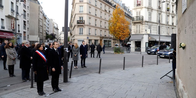 French President Emmanuel Macron and Paris mayor Anne Hidalgo, left, stand in front of a commemorative plaque facing the 'Le Carillon' bar and 'Le Petit Cambodge' restaurant during a ceremony marking the second anniversary of the Paris attacks, Monday Nov.13 November 2017.