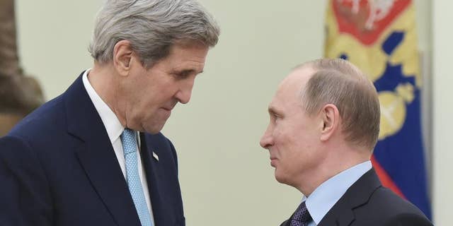 US Secretary of State John Kerry, left, speaks with Russia's President Vladimir Putin during a meeting at the Kremlin in Moscow Tuesday, Dec. 15, 2015. The United States and Russia need to find "common ground" to end Syria's civil war and restore stability in eastern Ukraine, U.S. Secretary of State John Kerry said Tuesday. (Mandel Ngan/Pool Image via AP)