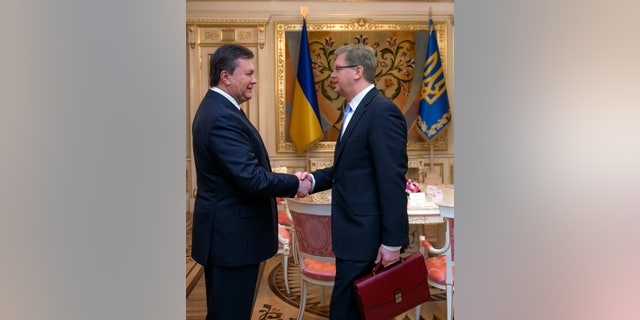 Ukrainian President Viktor Yanukovych, left, greets European Commissioner for Enlargement and European Neighborhood Policy Stefan Fule in Kiev, Ukraine, Wednesday, Feb. 12, 2014. (AP Photo/Andrei Mosienko, Pool)