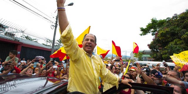 Luis Guillermo Solis, presidential candidate for the Citizen's Action Party, waves to supporters after casting his vote in the presidential runoff election in San Jose, Costa Rica, Sunday, April 6, 2014. Solis' only rival in the runoff dropped out of the race last month, leaving Solis one remaining challenge: getting enough Costa Ricans to the polls to give him a respectable vote total. (AP Photo/Moises Castillo)