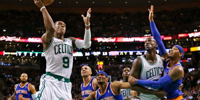 Boston Celtics guard Rajon Rondo (9) drives to the basket as Kevin Garnett blocks out New York Knicks forward Carmelo Anthony, right, during the first quarter of an NBA basketball game in Boston, Thursday, Jan. 24, 2013. (AP Photo/Charles Krupa)