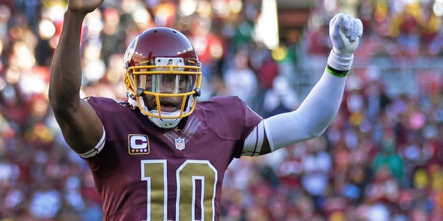 Washington Redskins quarterback Robert Griffin III celebrates a touchdown by fullback Darrel Young during the second half of a NFL football game against San Diego Chargers in Landover, Md., Sunday, Nov. 3, 2013. (AP Photo/Patrick Semansky)