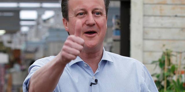 Britain's Prime Minister and Conservative Party leader David Camer gestures to supporters in Twickenham, London, Tuesday May 5, 2015. Britain will go to the polls in a national election on May 7. (AP Photo/Peter Nicholls, Pool)