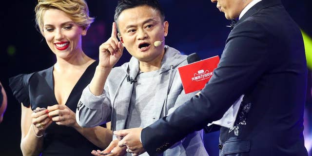 In this Thursday, Nov. 10, 2016 photo, Hollywood actress Scarlett Johansson, left, and Alibaba Group Chairman Jack Ma, center, attend an evening gala on the eve of the Singles Day online shopping festival in Shenzhen in southern China's Guangdong province.