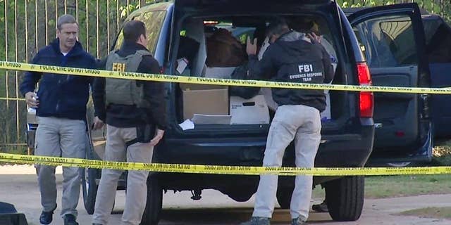 FILE - In this April 10, 2014, file photo taken from video, FBI agents collect evidence at an apartment complex in Atlanta, where federal agents rescued kidnap victim Frank Janssen, of Wake Forest, N.C. Kelvin Melton, a violent criminal described as a high-ranking member of the Bloods street gang goes on trial Monday, June 6, 2016, in North Carolina on a federal kidnapping charge after authorities say he helped orchestrate the abduction of Janssen, a prosecutor's father, from his prison cell. (AP Photo/Johnny Clark, File)