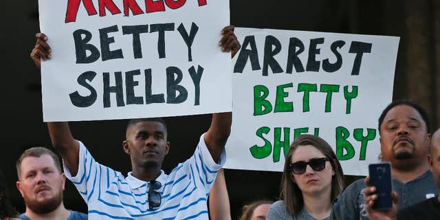 People hold signs at a "protest for justice" over Friday's shooting death of Terence Crutcher, sponsored by We the People Oklahoma, in Tulsa, Okla., Tuesday, Sept. 20, 2016. (AP Photo/Sue Ogrocki)