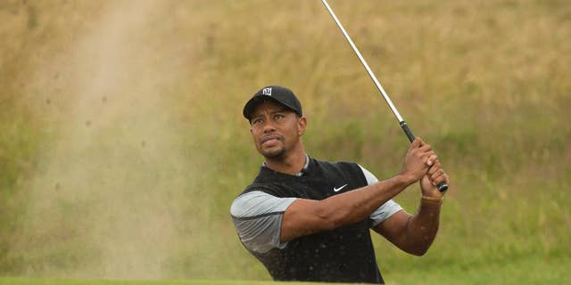 Tiger Woods of the US plays a shot from the bunker near the 15th green during a practice round at Royal Liverpool Golf Club prior to the start of the British Open Golf Championship, in Hoylake, England, Saturday, July 12, 2014. The 2014 Open Championship starts on Thursday July 17. (AP Photo/Jon Super)