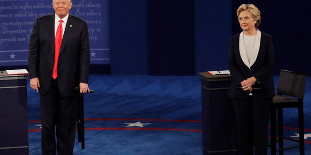 Republican presidential nominee Donald Trump and Democratic presidential nominee Hillary Clinton listen to a question during the second presidential debate at Washington University in St. Louis, Sunday, Oct. 9, 2016.