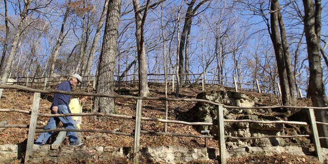 FILE - In this Nov. 8, 2010, file photo, pedestrians hike one of the trails at Effigy Mounds National Monument in Harpers Ferry, Iowa. Thomas Munson, the former superintendent of the monument, is scheduled to be sentenced Friday, July 8, 2016, in Cedar Rapids for stealing the remains of Native Americans who died hundreds of years ago. He's admitted to stealing a collection of ancient bones in 1990 and stashing them in his garage for two decades. (Justin Hayworth/The Des Moines Register via AP, File)