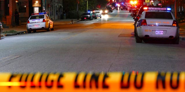 Police officers respond to Bennett Place and N. Fremont Avenue after a call went out that an officer is shot Wednesday, Nov. 15, 2017, in Baltimore, M.D. Baltimore police said in a tweet that one of their officers was shot Wednesday evening. The department did not immediately disclose the officer's name or any other details. (Kevin Richardson/The Baltimore Sun via AP)