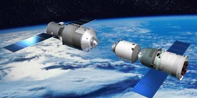 This illustration depicts a Chinese Shenzhou vehicle approaching the Tiangong 1 space lab during orbital rendezvous and docking tests, a precursor for space station construction.