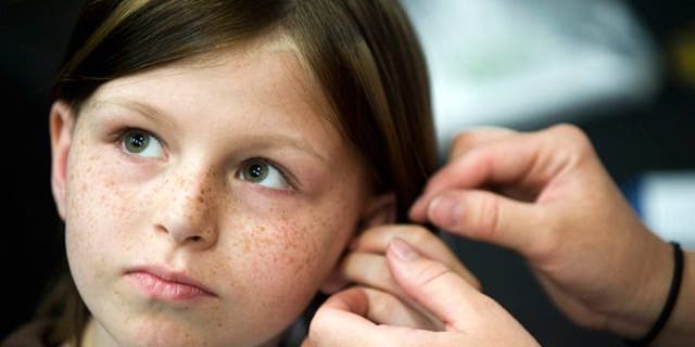 This May 2010 photo shows Zahra Baker, 10, getting a hearing aid at an event at Charlotte Motor Speedway.