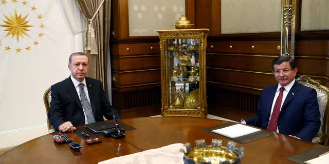 Turkish President Recep Tayyip Erdogan, left, and Prime Minister Ahmet Davutoglu attend a meeting at the presidential palace in Ankara, Turkey, Tuesday, Nov. 3, 2015. Turkish President Erdogan on Monday hailed a big victory for his ruling party in the country's parliamentary election and demanded the world respect the result.(AP Photo/Presidential Press Service, Pool)