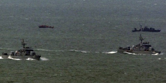 March 27: South Korean naval patrol ships (front) sail as a North Korean naval patrol ship (back R) approaches a repatriated North Korean fishing boat (back L) in the sea off South Korea's Yeonpyeong Island