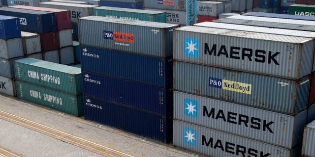 A worker walks past shipping containers piled at a port in Ningbo in east China's Zhejiang province, Tuesday, April 9, 2013. China reported higher import growth in March on Wednesday, April 10, 2013 in a possible positive sign for its economic recovery but analysts said doubts about the accuracy of Beijing's data made it hard to draw conclusions. (AP Photo) CHINA OUT