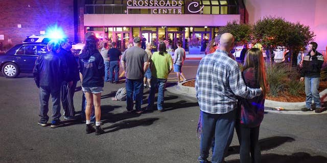 FILE - In this Sept. 17, 2016, file photo, people stand near an entrance of Crossroads Center shopping mall in St. Cloud, Minn., after several people were stabbed. FBI Director James Comey said Wednesday, Sept. 28, 2016, that the man who stabbed multiple people in the mall before being shot and killed appears to have been inspired, at least in part, by extremist ideology. (Dave Schwarz/St. Cloud Times via AP File)