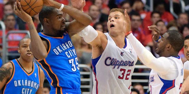 Oklahoma City Thunder forward Kevin Durant, left, passes the ball as Los Angeles Clippers forward Blake Griffin, center, and guard Chris Paul defend in the first half of Game 3 of the Western Conference semifinal NBA basketball playoff series, Friday, May 9, 2014, in Los Angeles. (AP Photo/Mark J. Terrill)