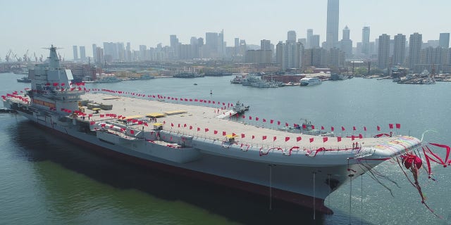 In this photo released by China's Xinhua News Agency, a newly-built aircraft carrier is transferred from dry dock into the water at a launch ceremony at a shipyard in Dalian in northeastern China's Liaoning Province, Wednesday, April 26, 2017.