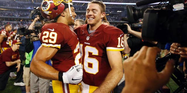 Washington Redskins' Roy Helu (29) and quarterback Colt McCoy (16) celebrate after an NFL football game against the Dallas Cowboys, Monday, Oct. 27, 2014, in Arlington, Texas. Washington won in overtime 20-17. (AP Photo/Tim Sharp)