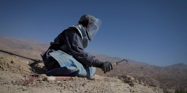 BAMIYAN, AFGHANISTAN - SEPTEMBER 2 : An Afghan deminer digs searching for mines and other munitions on top the archaelogical site of Shahr-i-Gholghola September 2 , 2009 in Bamiyan, Afghanistan. Afghan Technical Concultants (ATC) and the UN Mine Action center are working together to clear the ancient preserved ruins in the Bamiyan area, the project started on May 5th and will finish on October 15. On Shahr-i-Gholghola, there are 5 teams of deminers with 10 people each working on the ruins that date back to the 11th century. Aid workers say tourism is one of the greatest economic hopes for reviving this isolated and archaeologically stunning part of Afghanistan, a region that has seen little infrastructure development even though Bamiyan is one of the safest parts of the country. (Photo by Paula Bronstein/Getty Images)