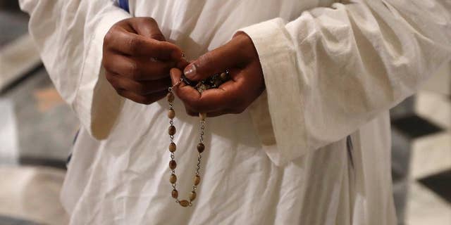 A nun of Mother Teresa's Missionaries of Charity holds a rosary during a vigil of prayer in preparation for the canonization of Mother Teresa in the St. John in Latheran Basilica at the Vatican in 2016.