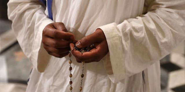 A nun of Mother Teresa's Missionaries of Charity holds a rosary during a vigil of prayer in preparation for the canonization of Mother Teresa in the St. John in Latheran Basilica at the Vatican in 2016.