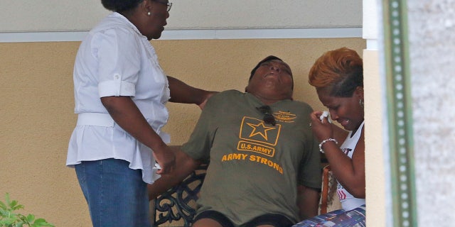 Oct. 20: Sharon Wright, Johnson's aunt, is aided by family after viewing the body.