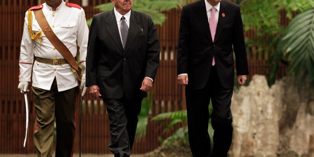Cuba's President Raul Castro, left center, and U.N. Secretary General Ban Ki-moon, right, review an honor guard at the Revolutionary Palace in Havana, Cuba, Monday, Jan. 27, 2014. (AP Photo/Pool)