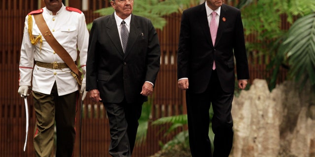 Cuba's President Raul Castro, left center, and U.N. Secretary General Ban Ki-moon, right, review an honor guard at the Revolutionary Palace in Havana, Cuba, Monday, Jan. 27, 2014. (AP Photo/Pool)